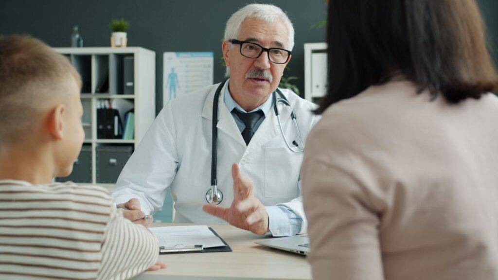 Doctor discusses with family during a medical consultation. Professional healthcare setting.